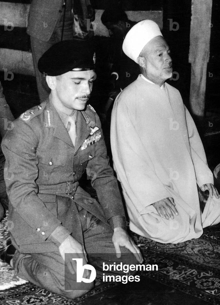 King Hussein of Jordan Kneeling For Prayer November 14, 1958 After The Syrian Bombings Over his Country (b/w photo)