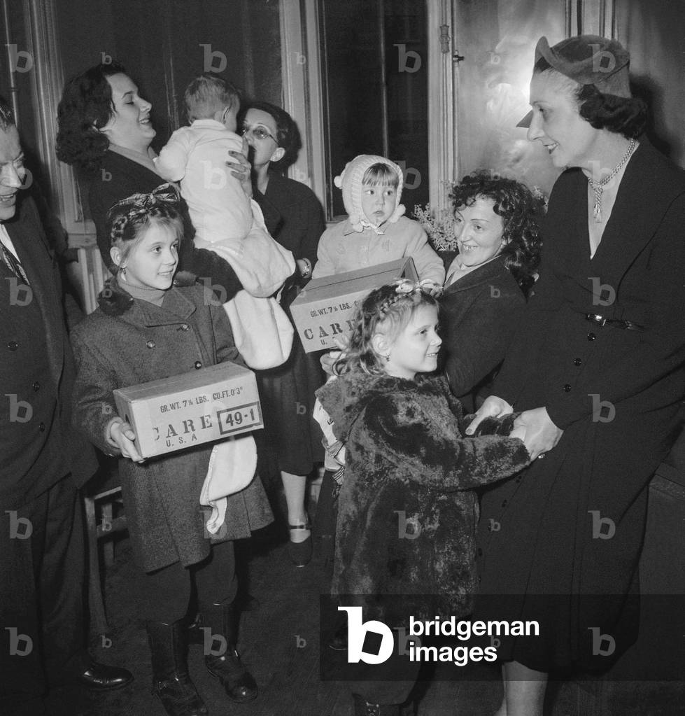 Mrs Vincent Auriol (Michelle Aucouturier) giving packets to refugees from Czechoslovakia, Poland, Hungary, in Paris December 20, 1949 (b/w photo)