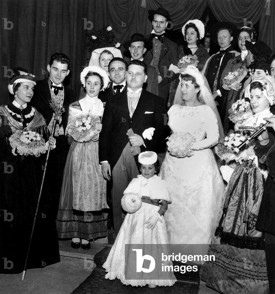 Wedding of Natives of The Auvergne, in Paris January 30, 1958 : Bride and Groom With Traditional Musicians and Women Wearing Traditional Suit (b/w photo)