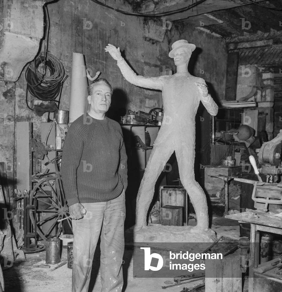 The sculptor Charles Kiffer and the statue of Maurice Chevalier for an old artists' home in Ris Orangis, France, April 17, 1963 (b/w photo)