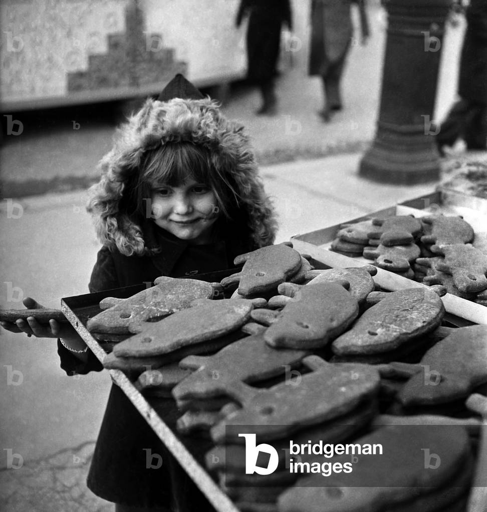 Young Girl With Gingerbread, Paris, April 5, 1947 (b/w photo)