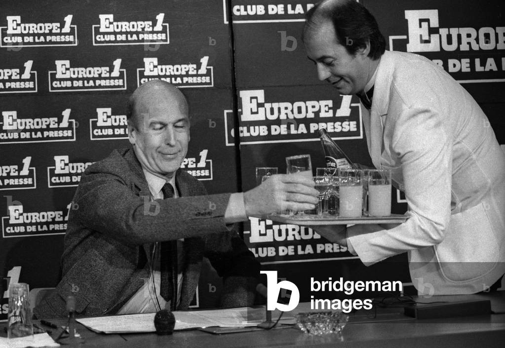 French politiican Valery Giscard d'Estaing (VGE) having a drink during radio program Club de la Presse in Paris, February 24, 1986 (b/w photo)
