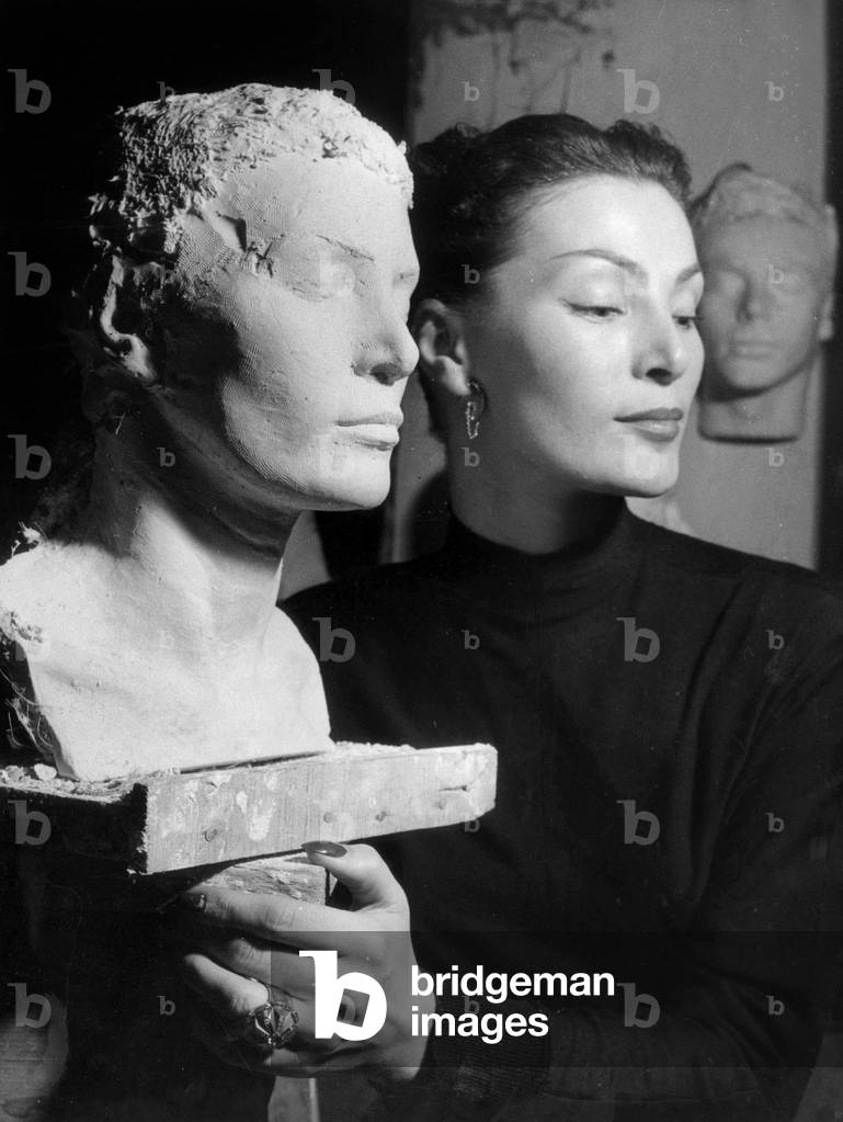 Model Lucie Daouphars Called Lucky, at The Models Club on December 14, 1951 Posing Near her Sculpted Portrait (b/w photo)