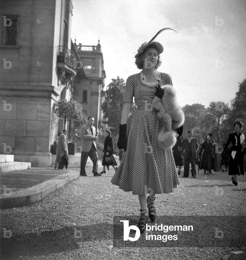Fashion in Longchamp, Paris, May 10, 1948 : Elegant Woman Wearing A Gingham Dress, Fur Stole, and Shoes With Lace (b/w photo)