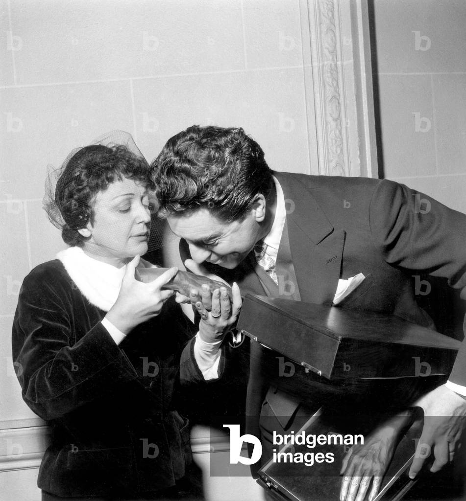 Edith Piaf and her Husband Jacques Pills Celebrating 1St Wedding Anniversary January 04, 1954 : Jacques Pills Is Kissing Bronze Casting of Hands of Piaf (b/w photo)