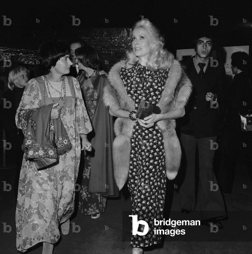 French film director and photograph Agnes Varda and french actress Catherine Deneuve arriving at JacquesDemy's 'A Slightly Pregnant Man' film premiere, on September 20, 1973