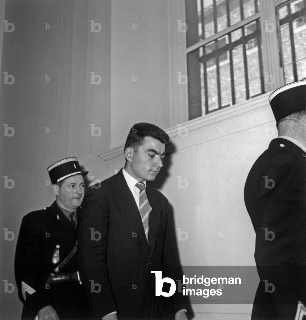 Jean Claude Vivier Escort Of Two Gendarmes Arriving In The Courtroom During The Trial Of The Assassins Of Saint Cloud On March 20, 1958 (b/w photo)