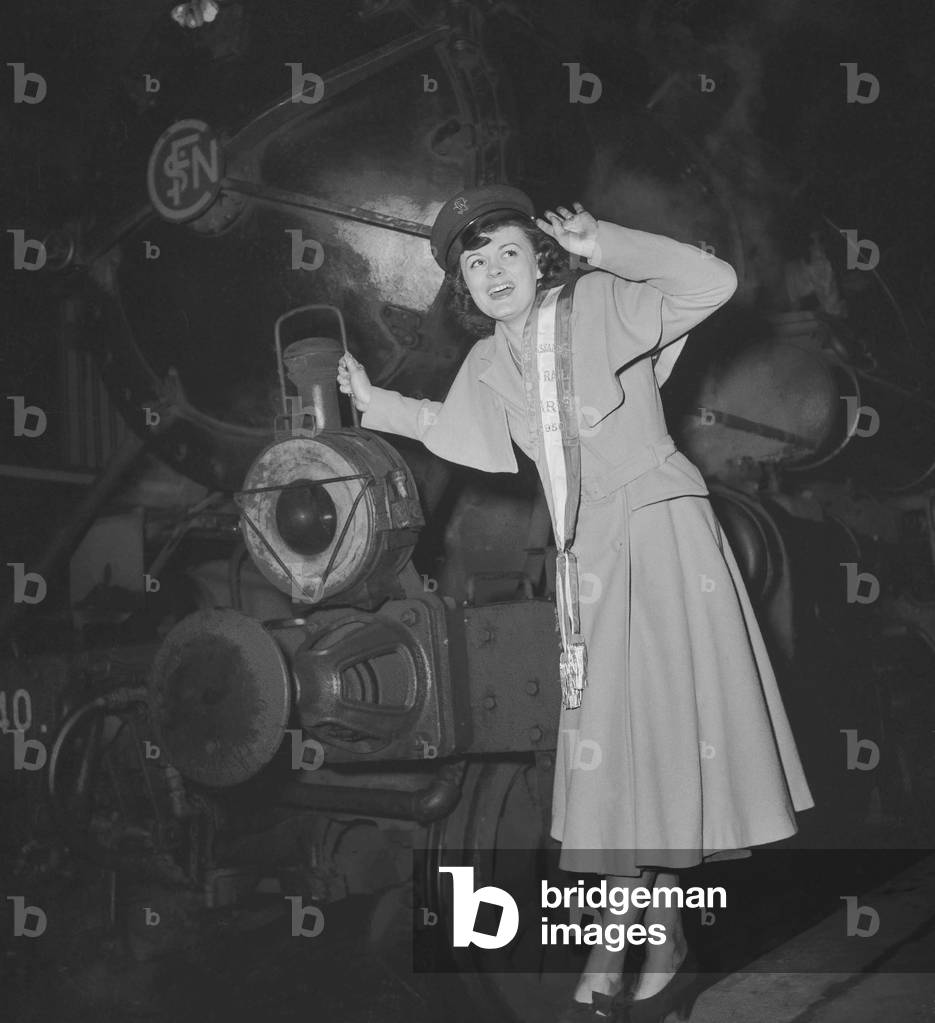 Jacqueline Simon has just been elected queen of the railwaymen and ambassador of the railway, near an engine at the Lyon station in Paris, February 6, 1950 (b/w photo)