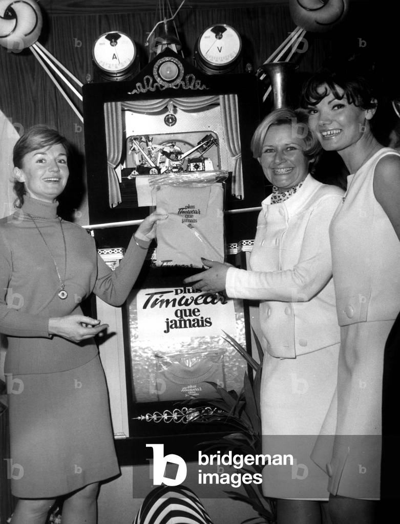 Brigitte Auber Left Godmother De La Trcomatique Invented By Bidulist Mendigal, The Machine That Knitts A Sweater In Three Seconds And Made “Tilt” Has Been Baptised At The Salon De Mesh At The Stand Timwear February 15, 1967 (b/w photo)