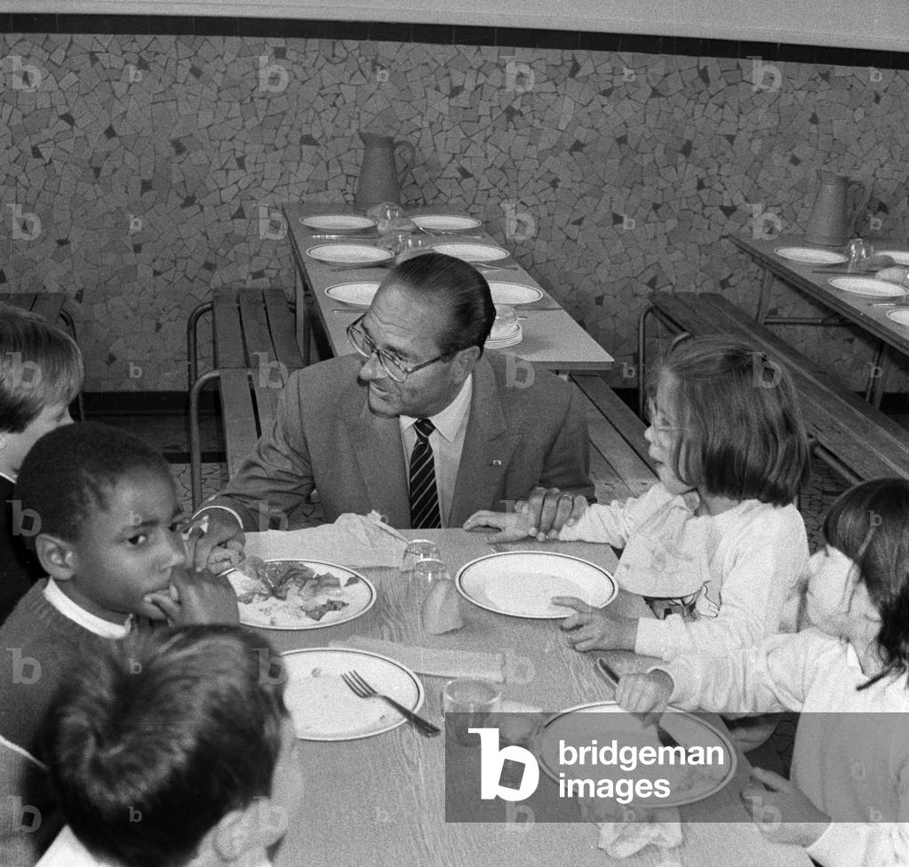 Mayor of Paris Jacques Chirac visiting a school, September 12, 1985 : here with children at the canteen (b/w photo)