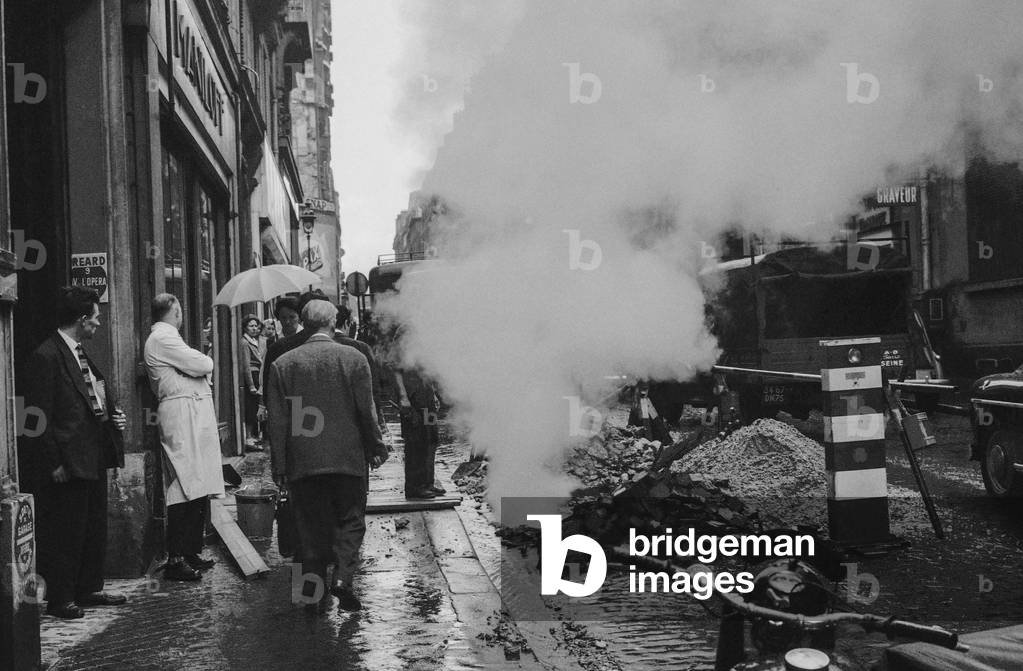 Steam in the street of Clichy in Paris caused by the rain on heating pipes, Paris, July 22, 1958 (b/w photo)