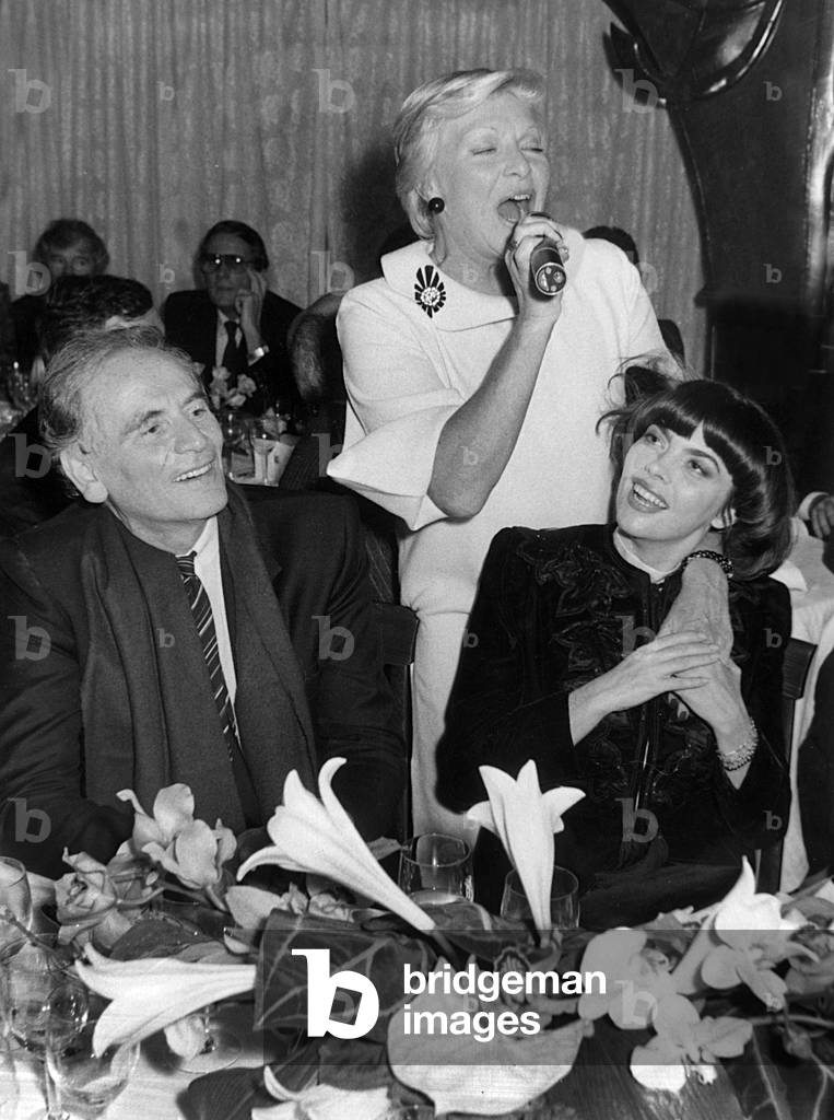 At Maxim'S Restaurant in Paris : Dinner For The 1St American Disc of Mireille Mathieu : Pierre Cardin Mireille Mathieu and Line Renaud on October 5, 1982 (b/w photo)