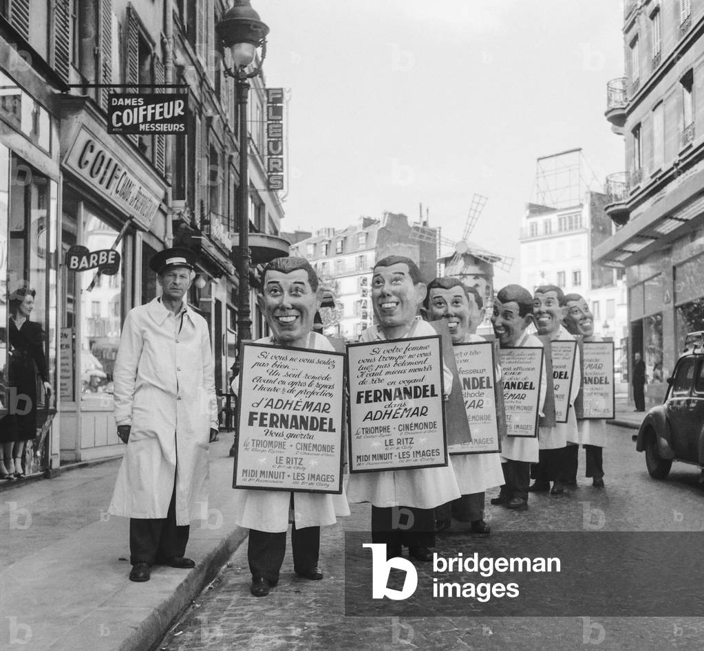 Men with a sandwich board and head of French actor Fernandel promoting the movie 