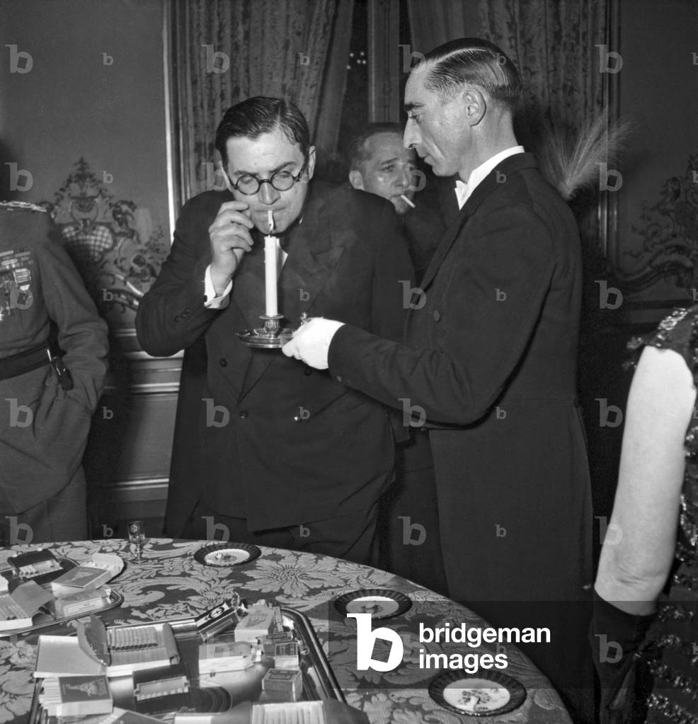 Reception Given at The Elysee, Paris, on February 23, 1949 : Mr Barreau, A Butler, Helping A Guest To Light A Cigarette (b/w photo)