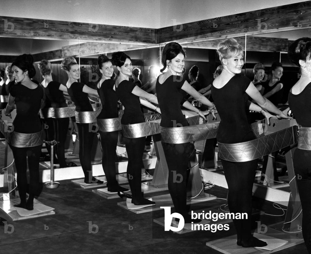 Blue Bell Girls In Black Pantyhose Participate in the Inauguration of “Silhouette” The New Women's Body Aesthetics Center with Specialized Mechanical and Electrical Vibration Appliance, Showers And Sauna On January 21, 1965 (b/w photo)