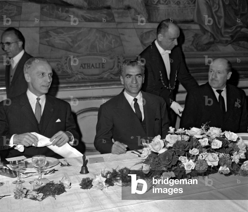 Visit of the Shah of Iran (Mohammad Reza Pahlavi) in Paris : here during a lunch organized by diplomatic press, at the Cercle Interallie, October 7, 1961. On l : Robert de Saint-Jean, president of the diplomatic press, on r : the Prince de Faucigny Lucinge (b/w photo)