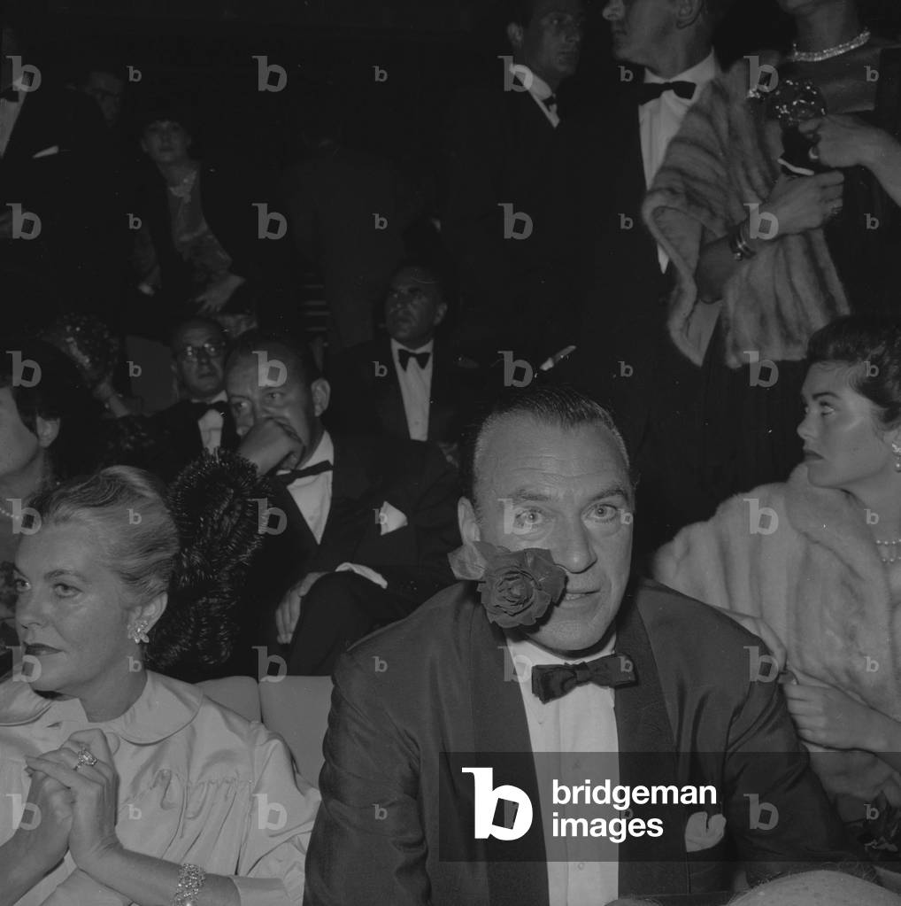 Gary Cooper (rose in mouth) and his wife attending premiere of film 