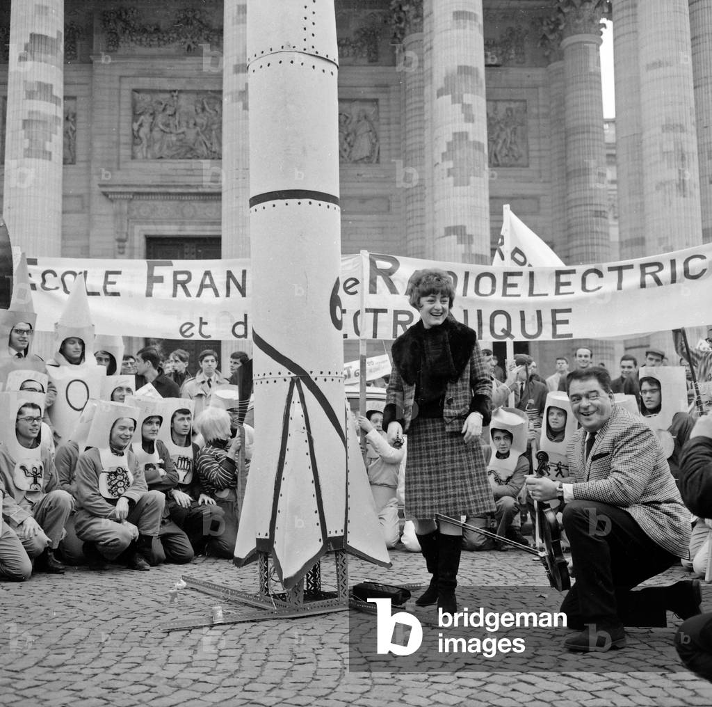 C28643 La Comedienne Marie Therese Orain Baptizes Les Bizuts Éleves De L'Ecole Francaise De Radio Electricite et D Electronics In The Latin Quarter Here In Front Of The Pantheon 27 January 1966 (b/w photo)