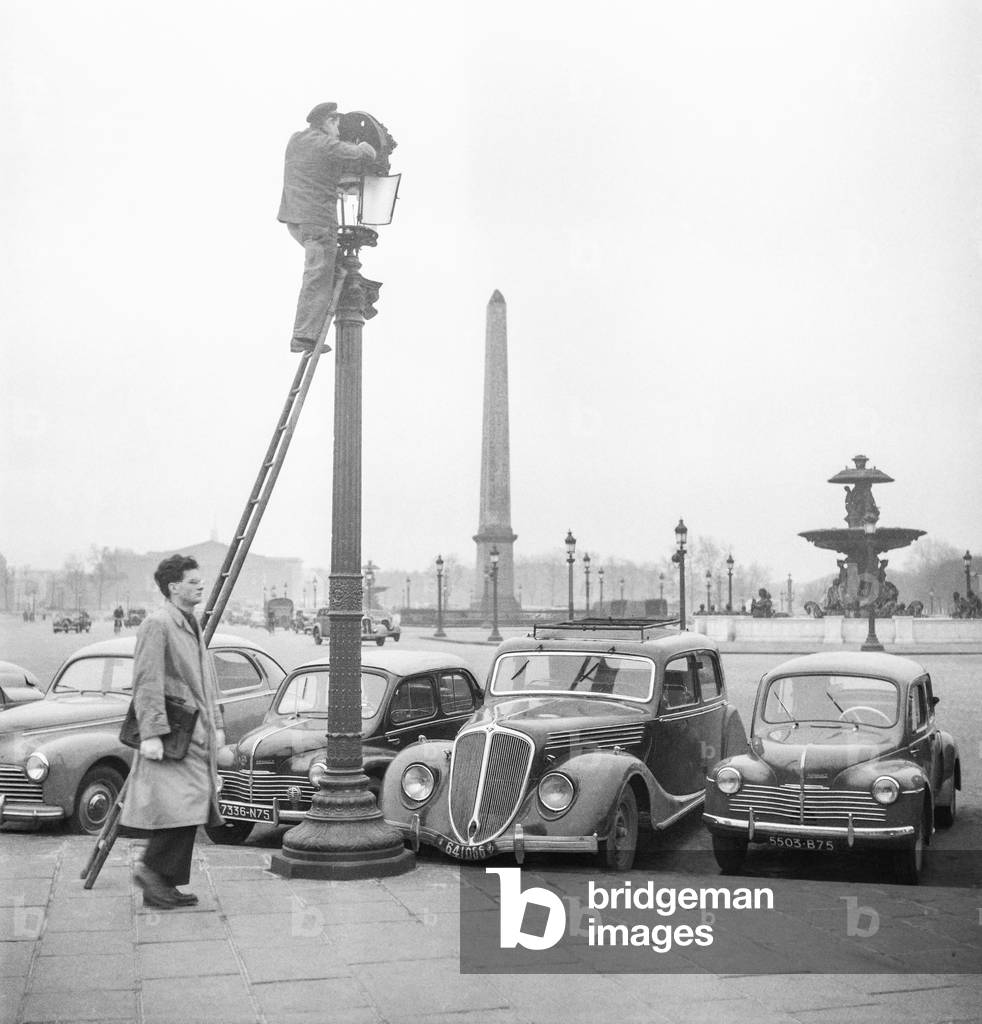 The Spring in Paris : cleaning of the street lamps on the Place de la Concorde, Paris, March 1951 (b/w photo)