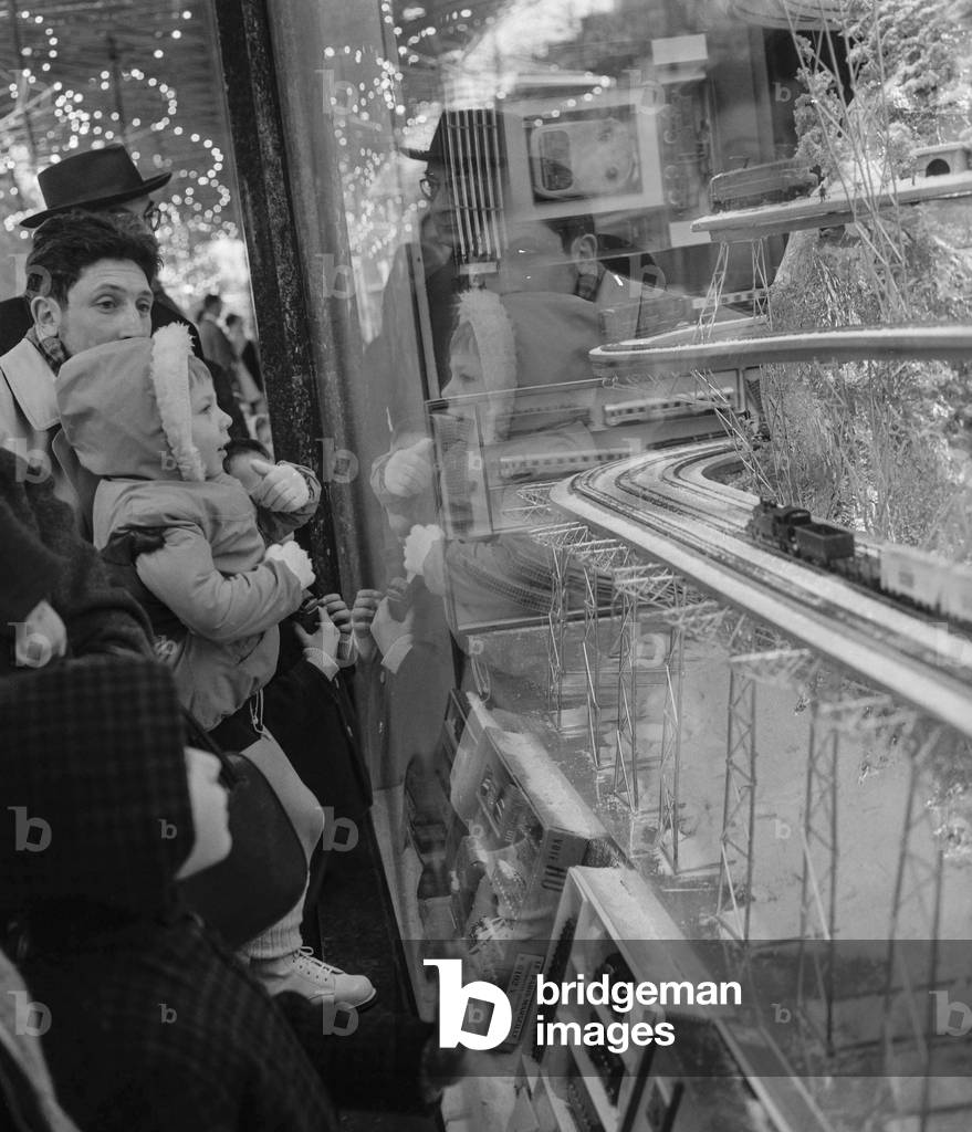 Child looking at an electric  train the shop window of a department store in Paris, before Christmas, November 13, 1960 (b/w photo)