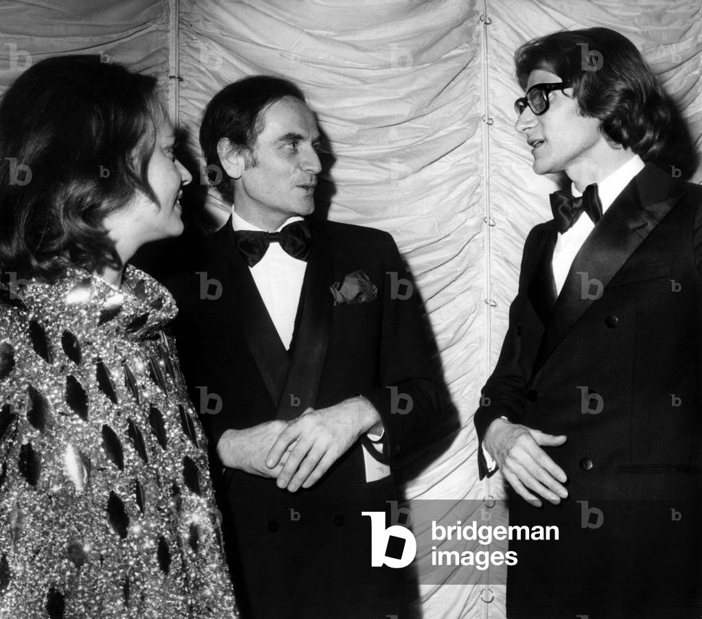 French Couturiers Pierre Cardin and Yves Saint-Laurent With Actress Jeanne Moreau at Premiere of Zizijeanmaire at Casino De Paris February 4, 1970 (b/w photo)