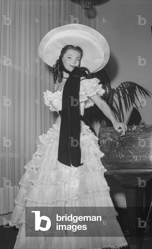 Election of the ideal Scarlett O'Hara in Paris, May 16, 1950 : Maggy Sarragne, the winer, with a dress by Carven (flounced dress and capeline) (b/w photo)
