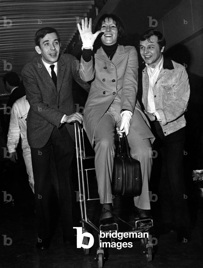 Singer Pia Colombo At Bourget Airport Before Her Depart To Moscow Here On A Carry Shoots By Her Accompanions Marc Hemler (Left) And Guy Jacquetin May 10, 1967 (b/w photo)