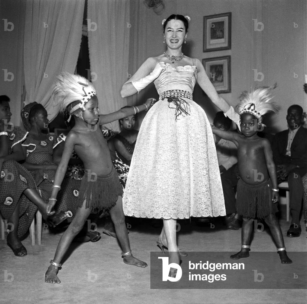 Child and Dancers of African Ballets of Keita Fodeba and A Model Wearing A Dress By Jacques Fath March 3, 1956, Paris (b/w photo)