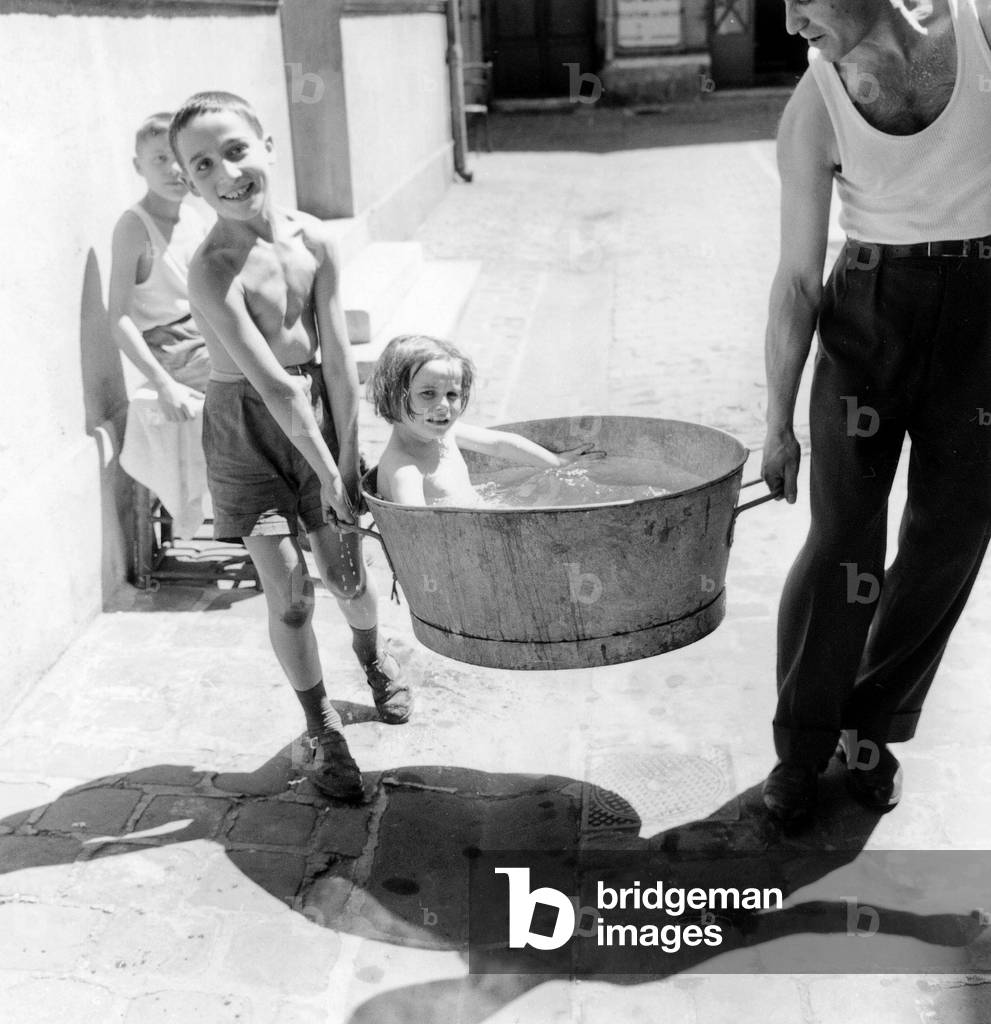 Heat in Paris : Little Girl Bathing in Tin Bowl July 05, 1959 (b/w photo)