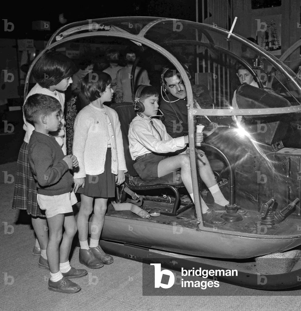 The childhood fair at the Grand Palais in Paris on October 30, 1960 : children in an Alouette helicopter (b/w photo)