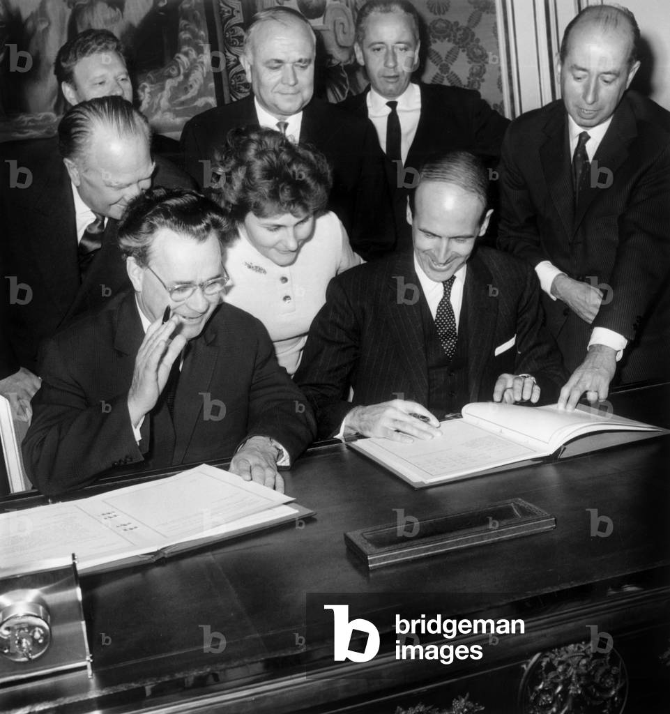 Nikolai Semyonovich Patolichev, Soviet Minister, and Valery Giscard D'Estaing, French Minister of Finances, Signing An Agreement Under Look of Ivan Matveievitch Vinogradov, Soviet Ambassador in Paris, October 30, 1964 (b/w photo)