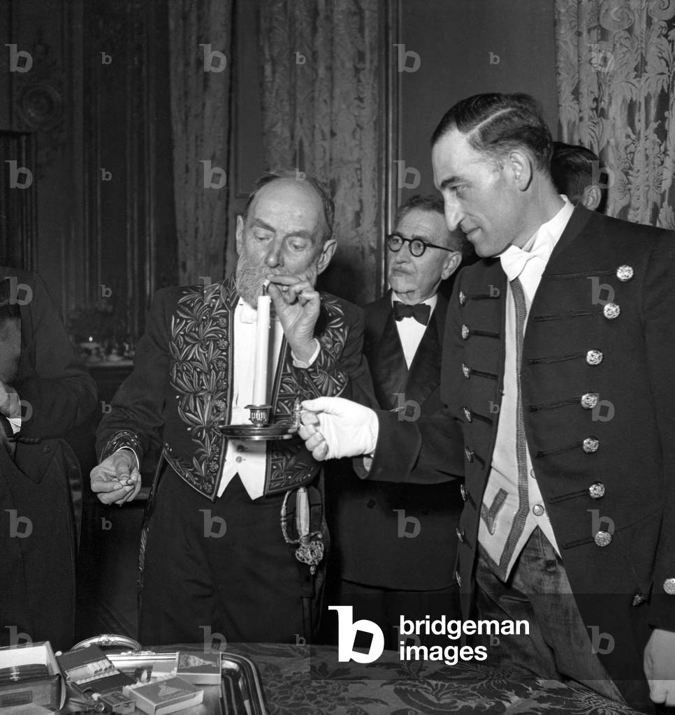 Reception at The Elysee, Paris, March 16, 1949 of The State Bodies : Edouard Payen Lighting his Cigarette With A Candle (b/w photo)