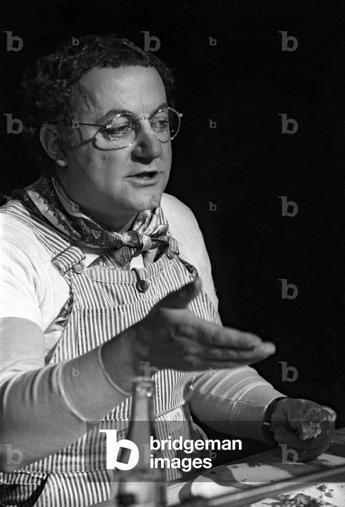 Coluche, candidate to French Presidential election, during a press conference at the Theatre du Gymnase in Paris, March 16, 1981. He's having a lunch before starting an hunger strike because he's not invited in political programs as the others candidates (b/w photo)