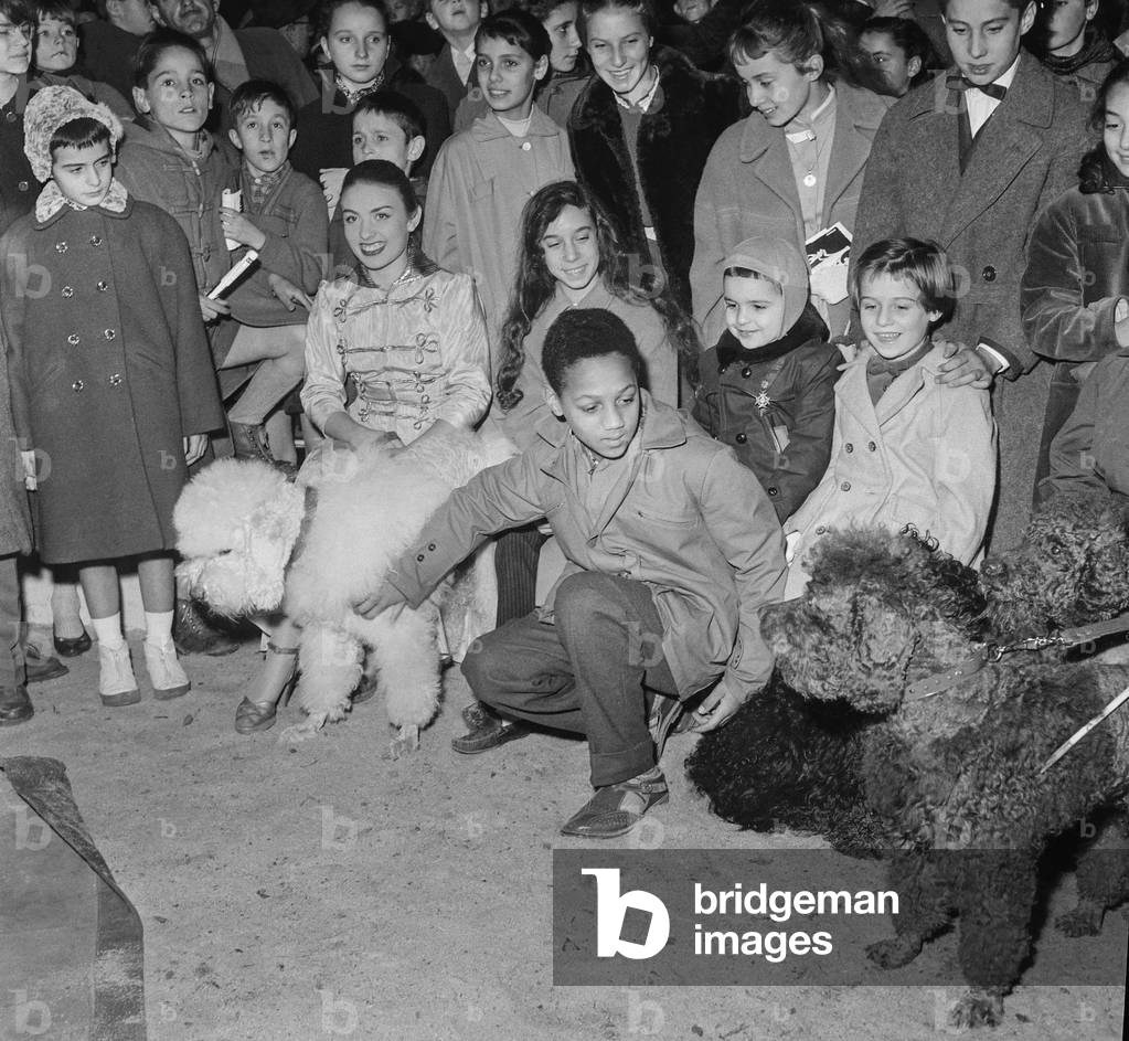 The childhood fair at the Grand Palais in Paris on November 8, 1956 : Tania Constantine, son of Gaston Monnerville, daughters of Mathilde Casadesus (b/w photo)