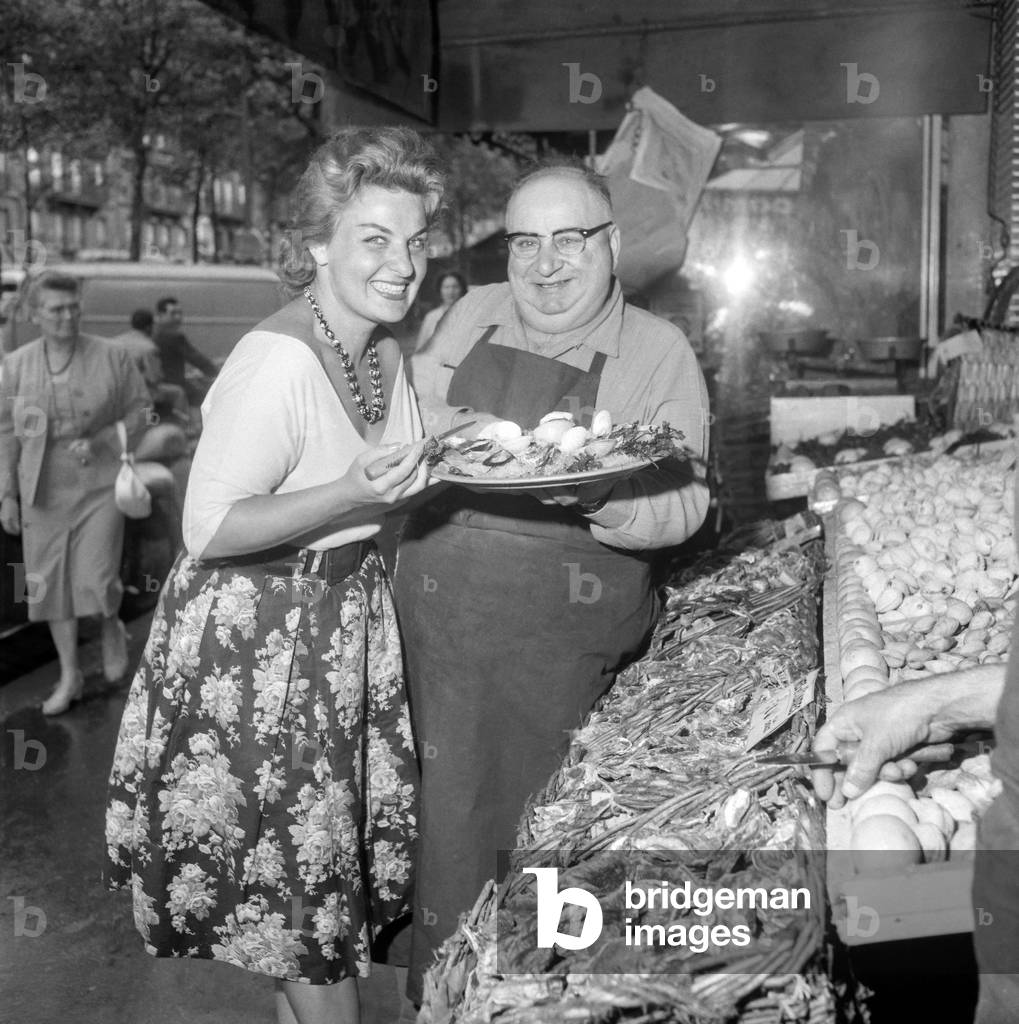 French singer Ginette Roland eating oysters at Charlot restaurant in Paris, August 30, 1960 (b/w photo)