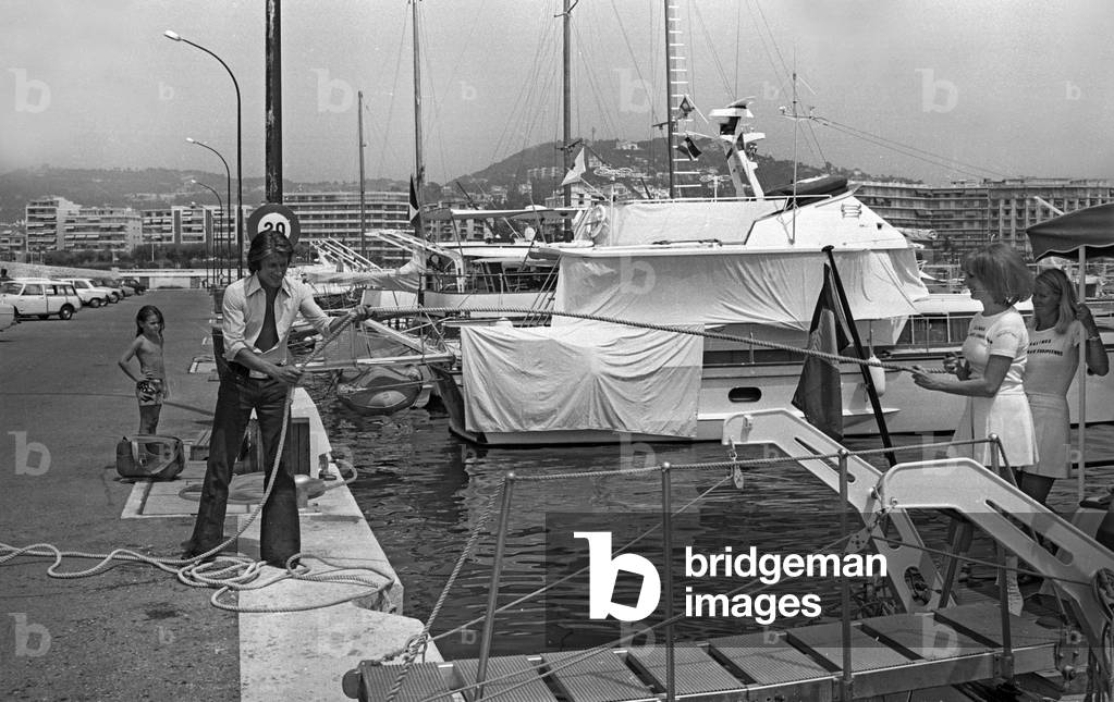 French singer Jacques Dutronc walking on the quayside in Cannes, France, July 28, 1971 (b/w photo)