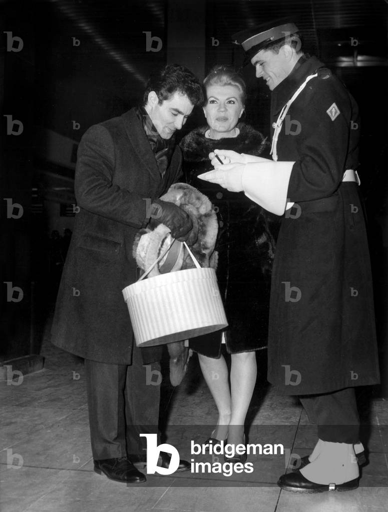 Opera Singer Jane Rhodes and Conductor Roberto Benzi at Orly Airport Leaving For Their Honeymoon in Canada December 29, 1966 : Signing An Autograph To A Member Or Riot Squad (b/w photo)
