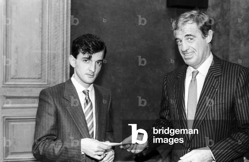 French actor Jean Paul Belmondo giving French sculptor Mauro Corda the PaulBelmondo award on December 5, 1985 (b/w photo)