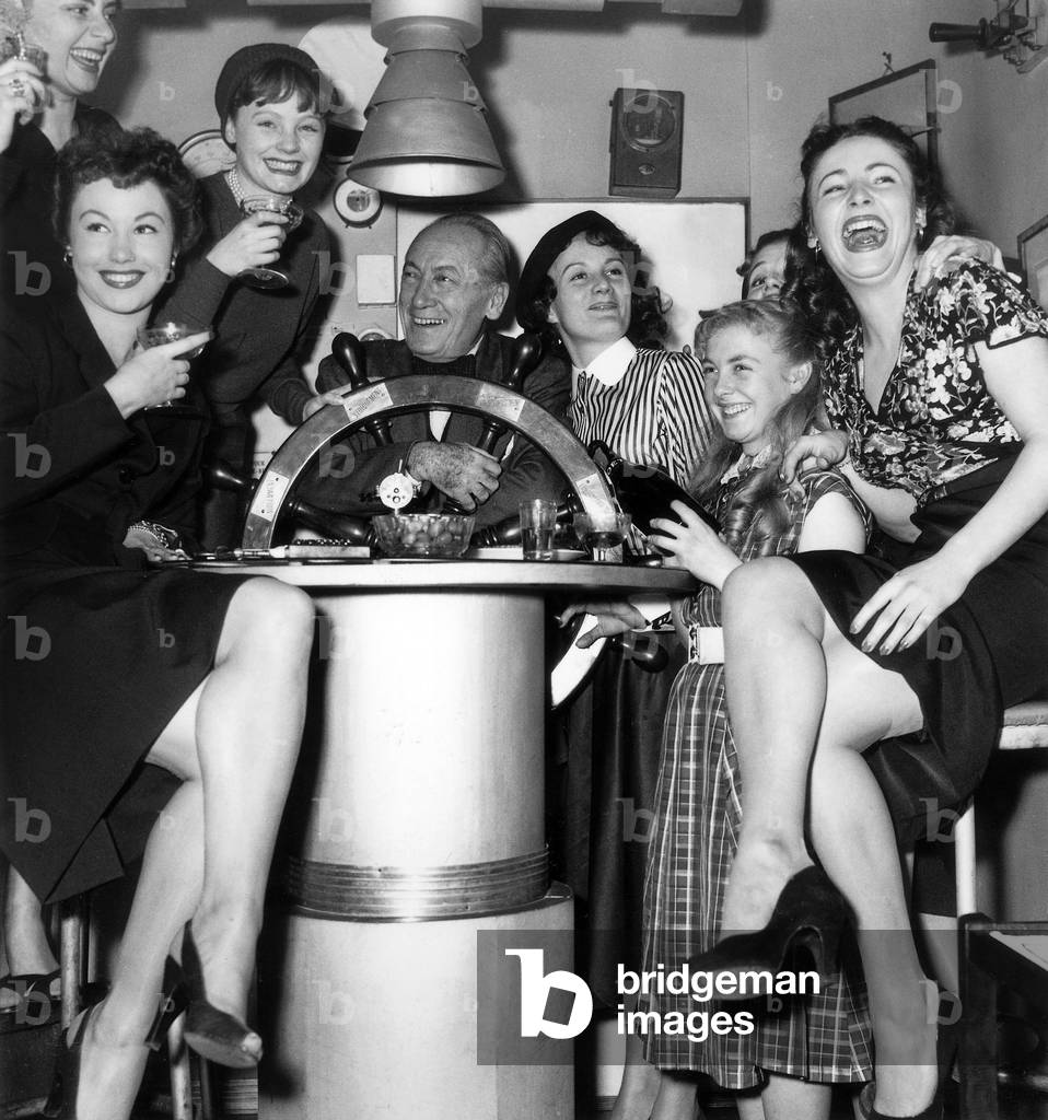 French Author of Detective Stories Maurice Dekobra in his Parisian Apartment With French Actresses Who Will Play in his Movie November 12, 1952 (b/w photo)