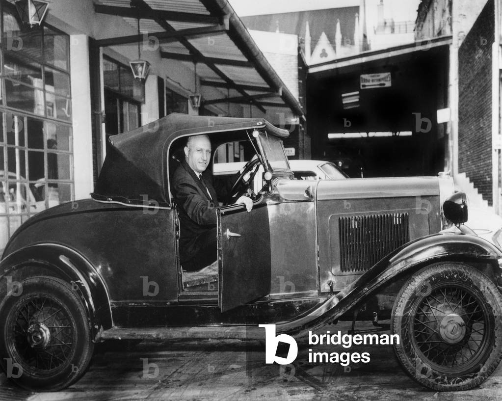 Juan Manuel Fangio Driving on Old Model of Alfa Romeo Car January 5, 1965 (b/w photo)