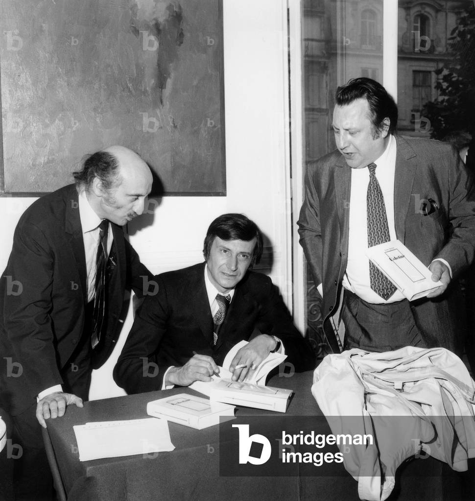 French Writer Louis Nucera Signing his First Novel L' Obstine To French Humorists Raymond Devos (R) and Teddy Vrignault Member of The Band Freres Ennemis June 17, 1970 (b/w photo)