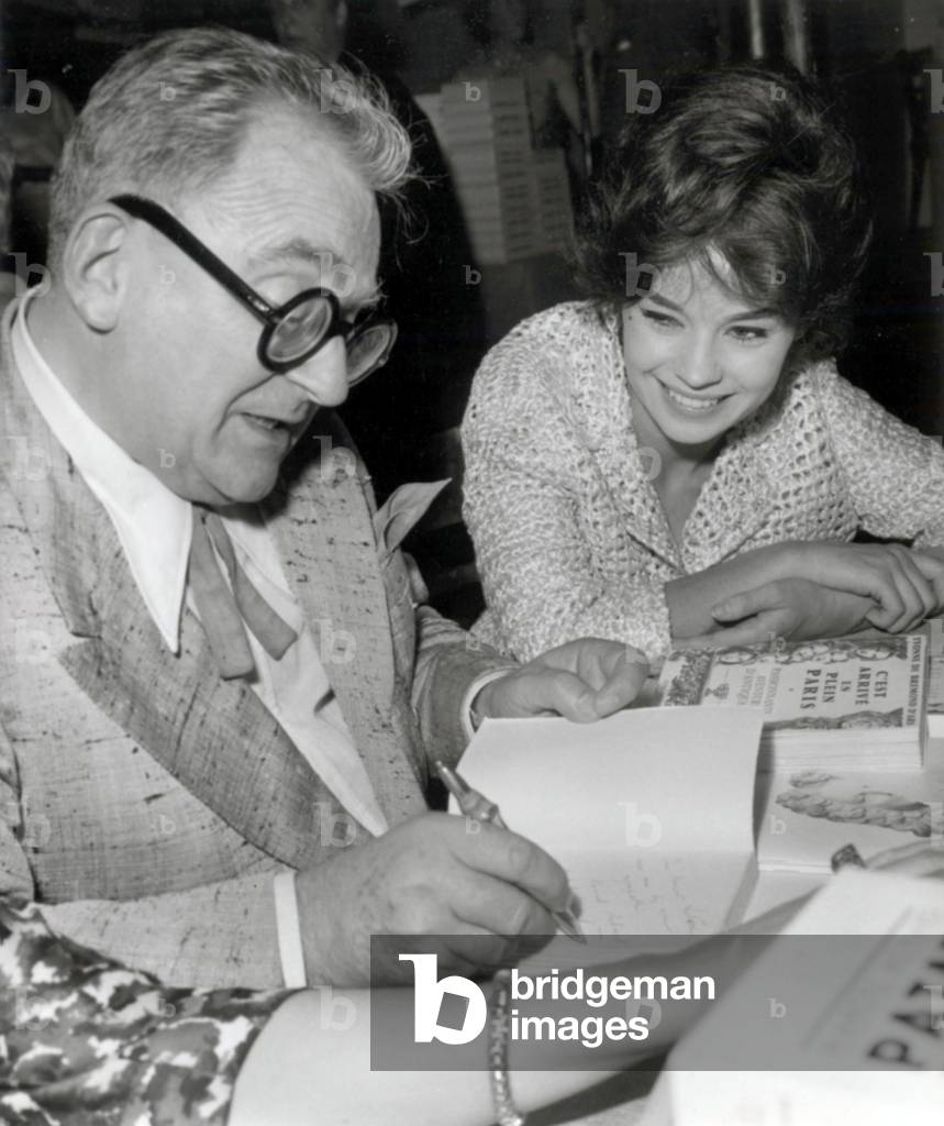 The French Writer Marcel Achard in Paris Sign his Book For The Actress Pascale Petit, June 5, 1959 (b/w photo)