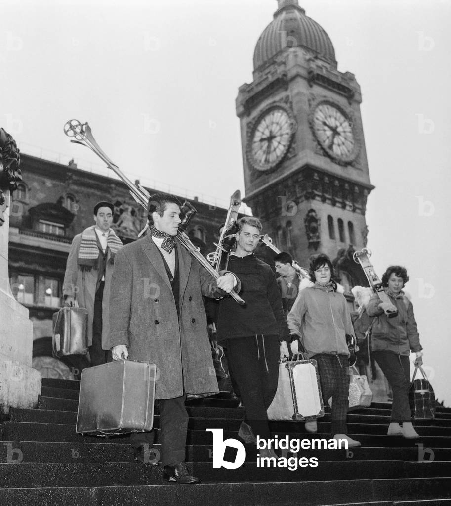 Holidaymakers are back from mountains, here with their skis at the Gare de Lyon, Paris, January 2, 1961 (b/w photo)