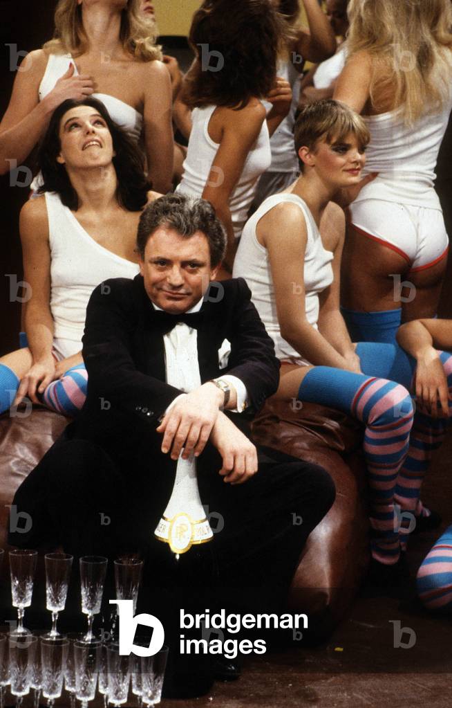 Jacques Martin During the Recording of the Show “Gym Tonic” Surrounded by Strippers Du Crazy Horse November 29, 1983 (b/w photo)
