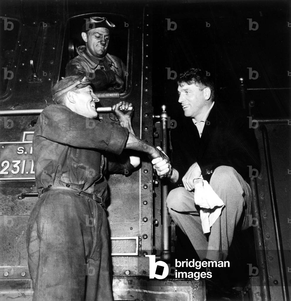 Burt Lancaster Arriving in Saint Lazare Railway Station in Paris here Shaking Hands With Conductors June 29, 1955 (b/w photo)