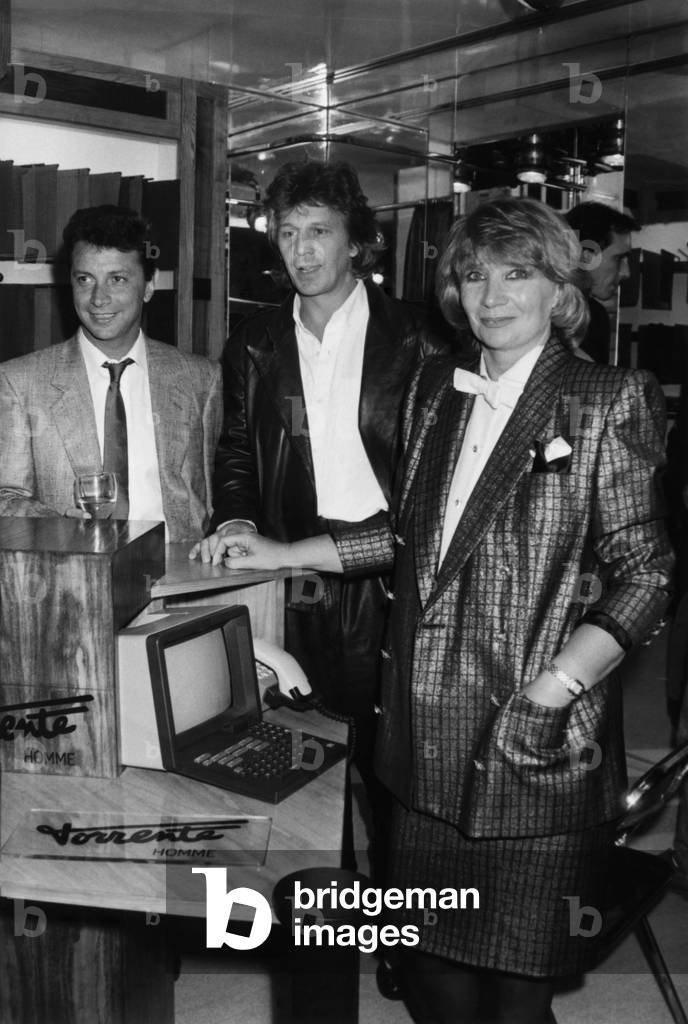 Herve Villard And Gerard Lenorman, At The Presentation By Madame Torrent-Mett, Of The Custom Costumes, Orders On Minitel, X-ray Traces And Laser Cups In 7 Days. September 10, 1986 (b/w photo)