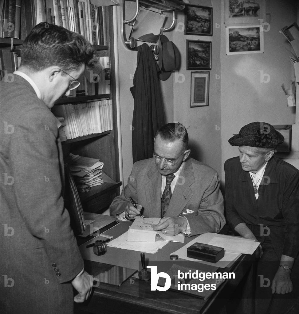 German writer Thomas Mann signing his books, Paris, May 11, 1950 (b/w photo)