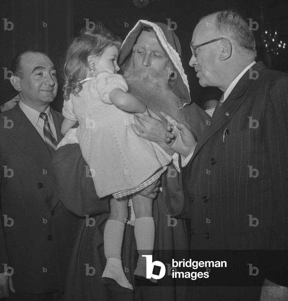 Celebration of Christmas at the Elysee, Paris, December 22, 1949 : French president Vincent Auriol with Santa Claus and a young girl (b/w photo)