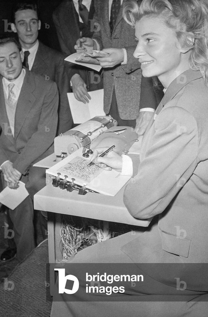 Young woman using the Electrosyl (electronic typewriter invented by Albert Ducrocq), Paris, November 14, 1956 (b/w photo)