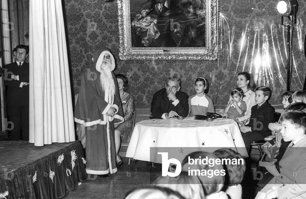 The Christmas for the children of Monaco, at the Prince's Palace of Monaco, December 22, 1967 : Santa Claus, Prince Rainier III of Monaco, Princess Caroline, Princess Grace with Dtephanie and Prince Albert (future Albert II) (b/w photo)